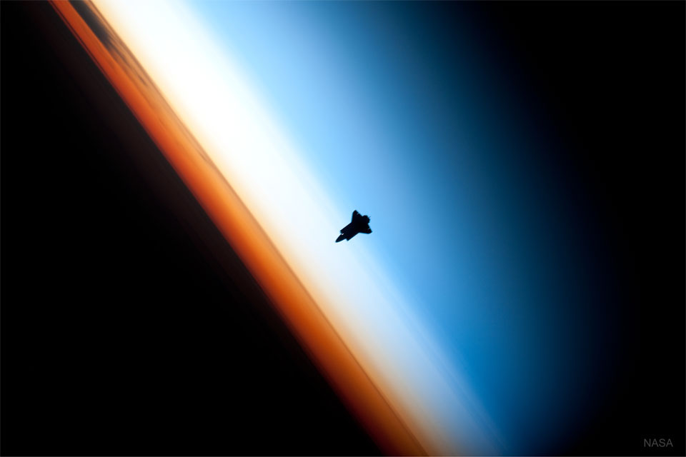 Prezentowane zdjęcie przedstawia prom kosmiczny NASA, zbliżający się do Międzynarodowej Stacji Kosmicznej, z Ziemią widoczną w tle.
Więcej szczegółowych informacji w opisie poniżej.