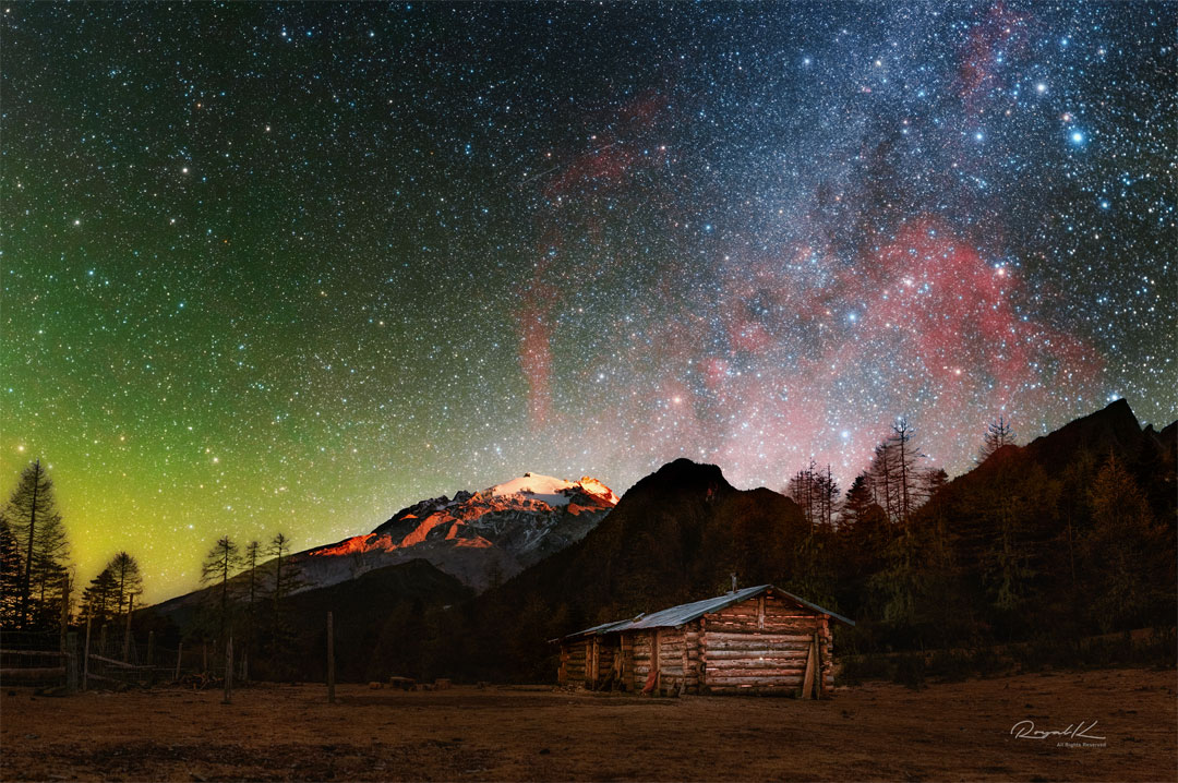 The featured image shows expansive Gum Nebula,
glowing in red, behind a landscape with a wooden hut 
and snowy mountains. 
the unusual light
Please see the explanation for more detailed information.