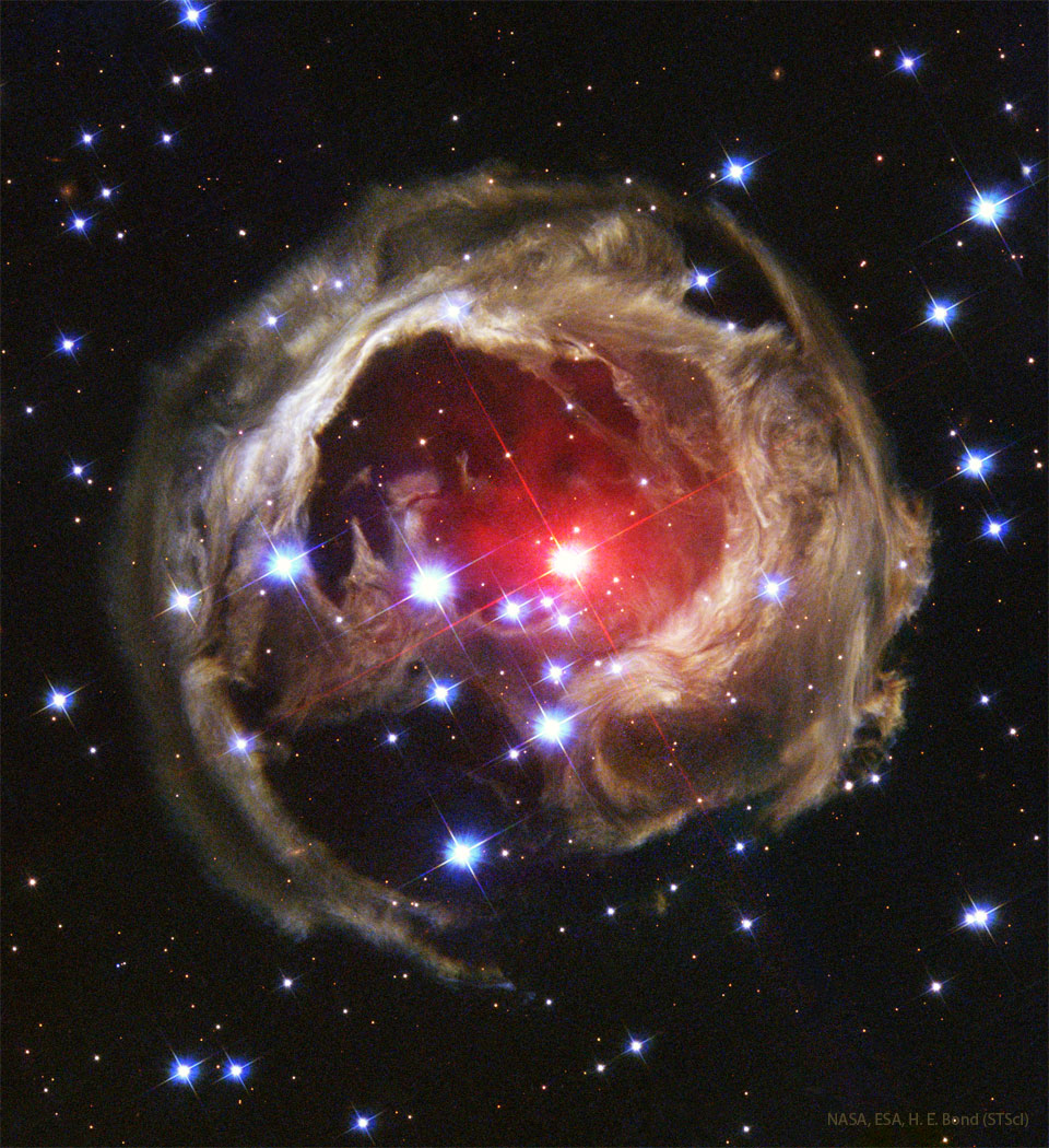 Opisywane zdjęcie pokazuje niezwykły kształt
echa świetlnego, znanego jako V838 Mon. Oświetlony
pył jest niejednolity i otacza jasną czerwoną gwiazdę.
Zobacz opis. Po kliknięciu obrazka załaduje
się wersja o największej dostępnej rozdzielczości.