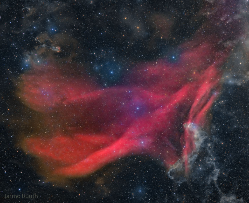 Prezentowane zdjęcie przedstawia gwiazdy oraz świecące, czerwone fale Wielkiej Mgławicy Jaszczurki. Więcej szczegółowych 
informacji w opisie poniżej.