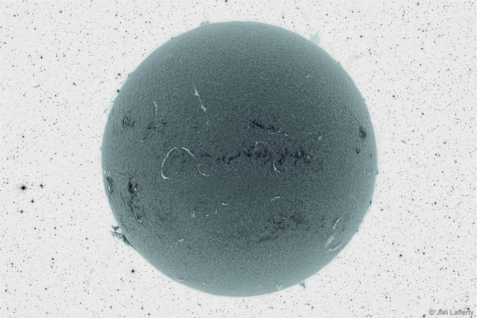The featured image shows a dark ball covered with light
and dark markings in front of a color-negative starfield 
Please see the explanation for more detailed information.