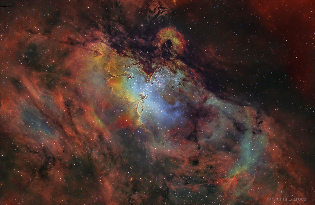 Głębokie zdjęcie Mgławicy Orzeł przedstawione jest w naukowo przypisanych barwach. Obszar wokół mgławicy jest czerwony, a jej wnętrze niebieskie. Widoczne są również 
      liczne, niezwykłe filary. Więcej szczegółowych informacji w opisie poniżej.
