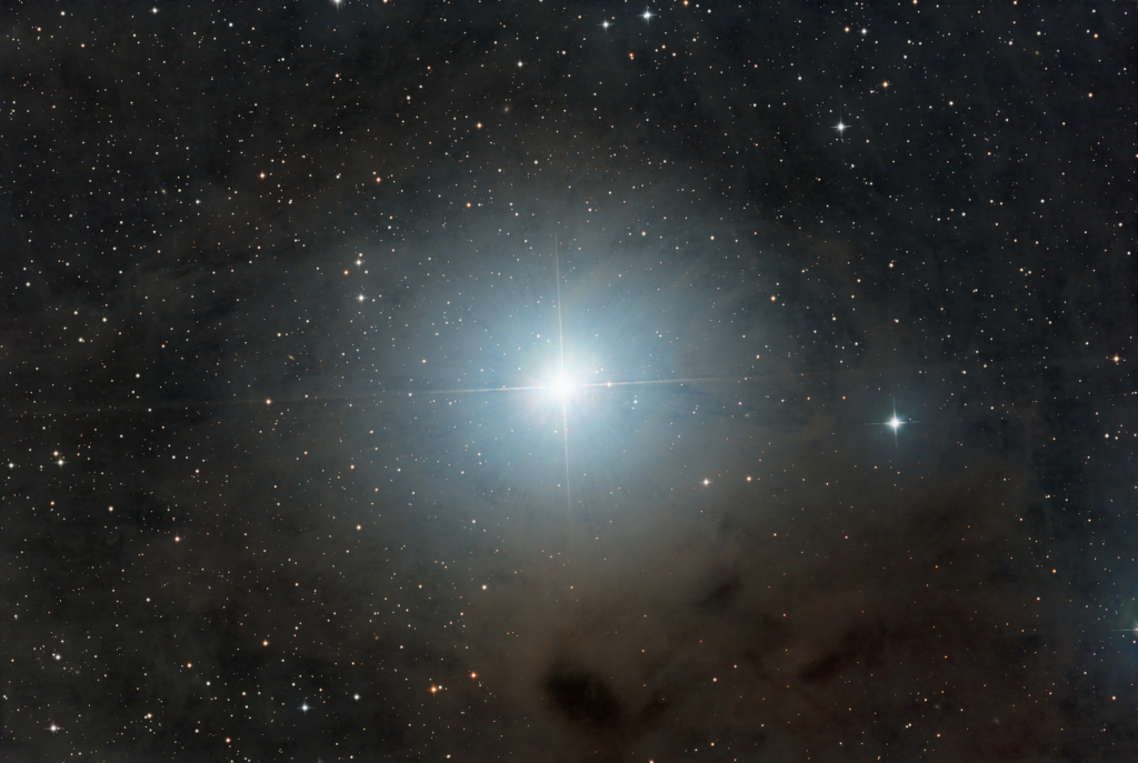 Na zdjęciu pokazano słynną gromadę gwiazd Plejady otoczoną przez pył.
Jego fragmenty blisko jasnych gwiazd odbijają niebieskie światło, lecz 
odleglejsze fragmenty wyglądają na czerwieńsze. Zobacz opis. Po kliknięciu obrazka załaduje się wersja
o największej dostępnej rozdzielczości.