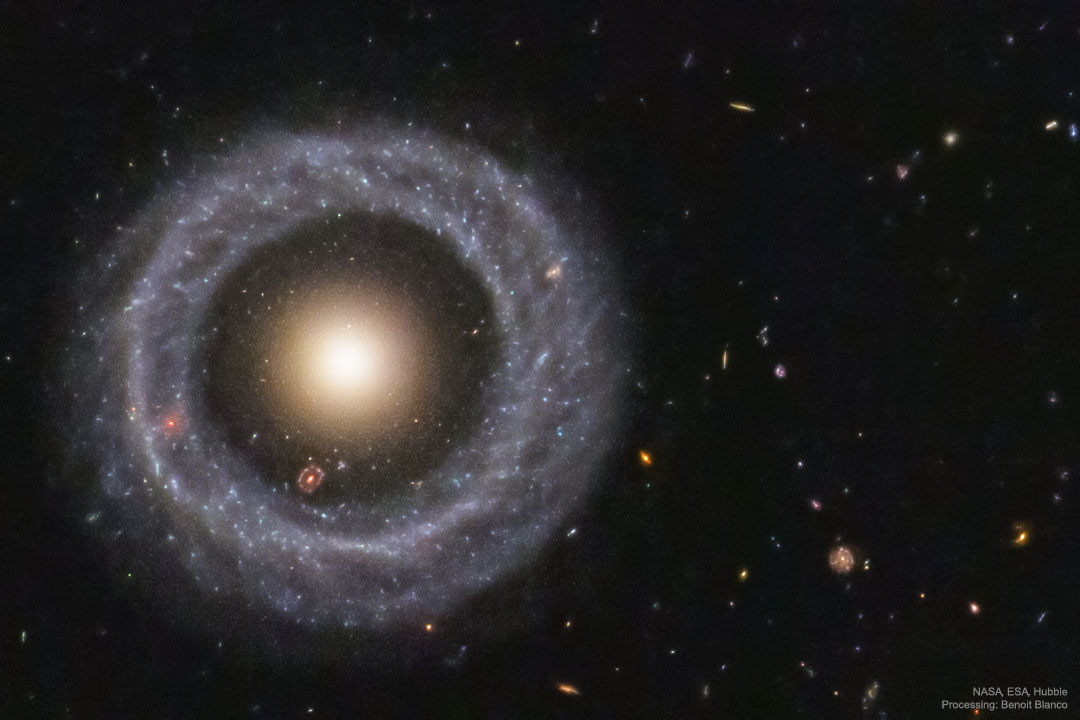 Na ciemnym polu pełnym małych galaktyk tła widoczny jest niemal idealnie okrągły pierścień 
niebieskich gwiazd. W centrum pierścienia znajduje się kula żółtych gwiazd.
Więcej szczegółowych informacji w opisie poniżej.