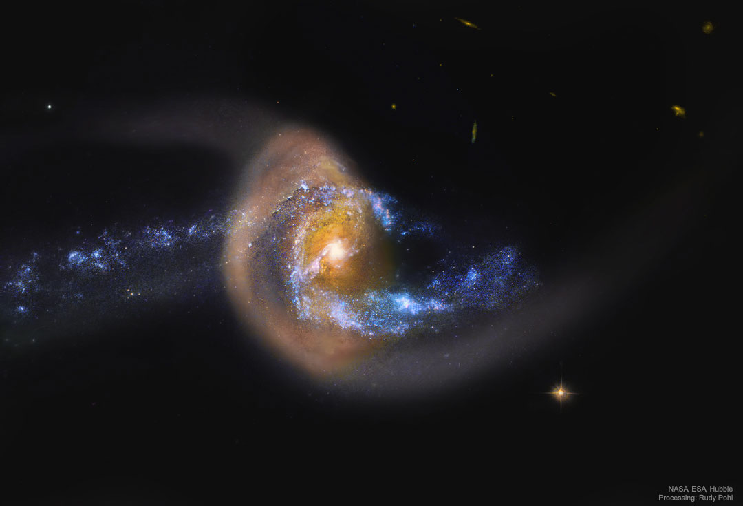 Wydaje się, że błękitna galaktyka spiralna zderza się
-- i prawdopodobnie przelatuje przez -- brązową galaktykę pyłową.
Zobacz opis. Po kliknięciu obrazka załaduje się wersja
 o największej dostępnej rozdzielczości.