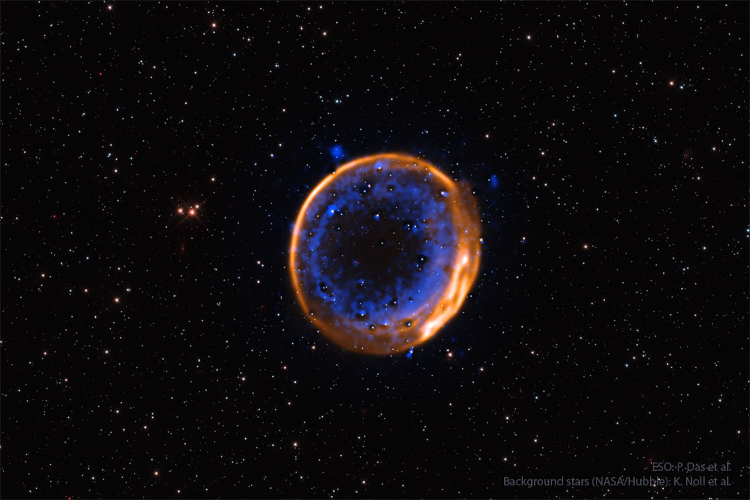 A nearly circular nebula with two rings is shown. 
The outer ring appears orange while while the inner 
rings is more complex and appears blue. 
Więcej szczegółowych informacji w opisie poniżej.