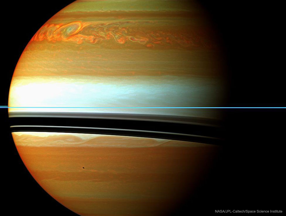 Na zdjęciu pokazano planetę Saturn w podczerwieni
z dużą szczegółowością, widoczną na szczytach jej chmur.
Pierścienie wyglądają jak cienka błękitna pozioma linia.
Ich cienie natomiast wyglądają jak zakrzywione ciemne linie
na chmurach. Blisko górnej krawędzi jedno z pasm brązowych
chmur wydaje się dość skotłowane. Zobacz opis. Po kliknięciu obrazka załaduje się wersja
 o największej dostępnej rozdzielczości.