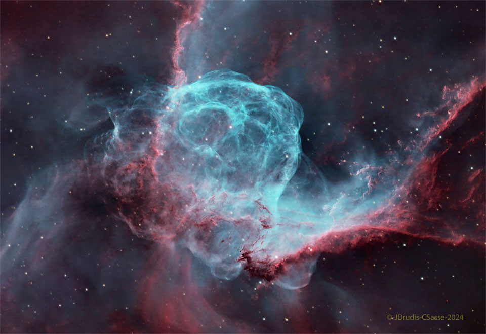 A starfield surrounds a complex nebula with many red
and blue filaments. Dark streams of dust also populate 
the nebula. 
Więcej szczegółowych informacji w opisie poniżej.